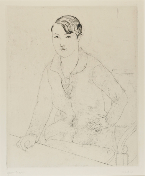 YOUNG WOMAN SEATED IN AN ARMCHAIR