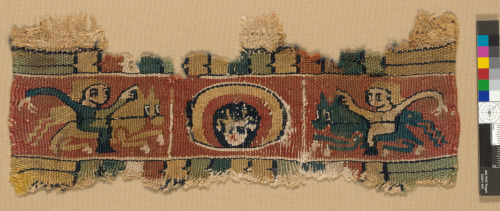 FRAGMENT OF BAND OR CLAVUS WITH SAINT’S HEAD FLANKED BY HORSEMEN