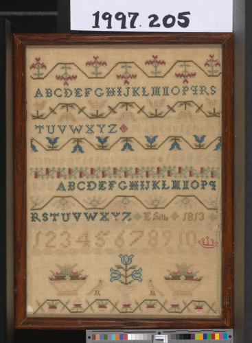Band sampler with alphabets, floral baskets, etc.