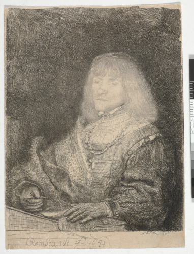 MAN AT A DESK, WEARING A CROSS AND CHAIN