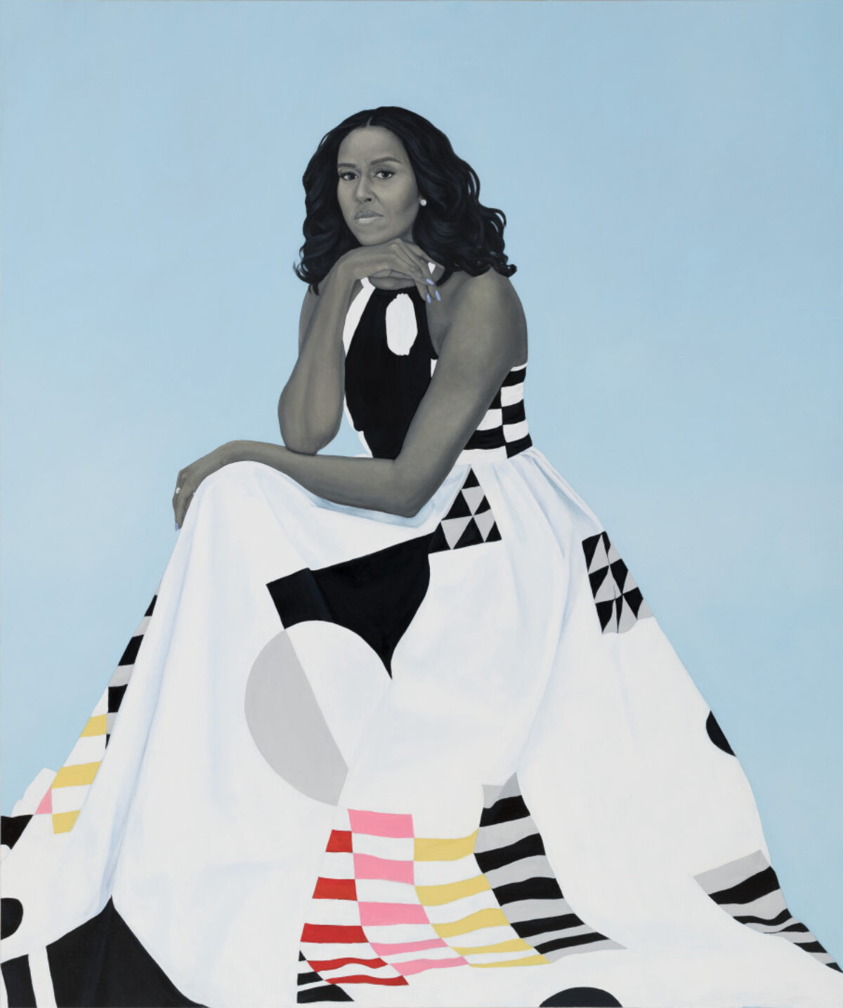 A portrait of Michelle Obama seated, looking forward, with her chin resting on her hand. She wears a dress with a black and white halter top and a full white skirt featuring geometric patterns in black, white, gray, pink, yellow, and red. The background is solid light blue.